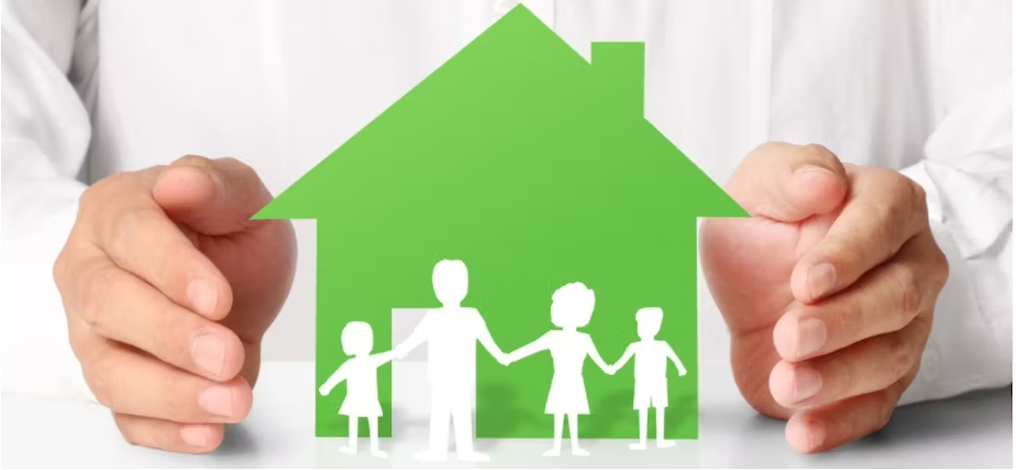 un homme tient une maison en papier avec une famille entre les mains